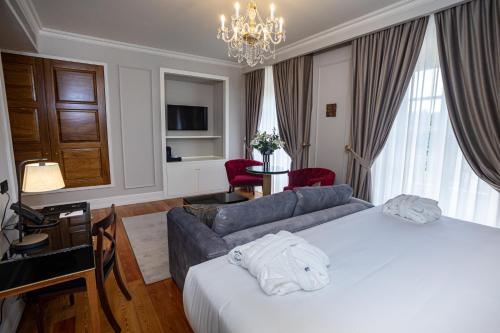 a hotel room with a bed and a couch at Solar do Requeijo by Luna Hotels & Resorts in Arcos de Valdevez