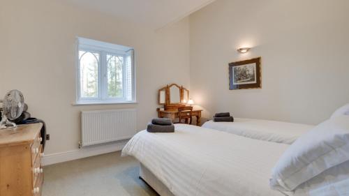 Two Dales的住宿－Frogmore Cottage，一间卧室设有两张床和窗户。
