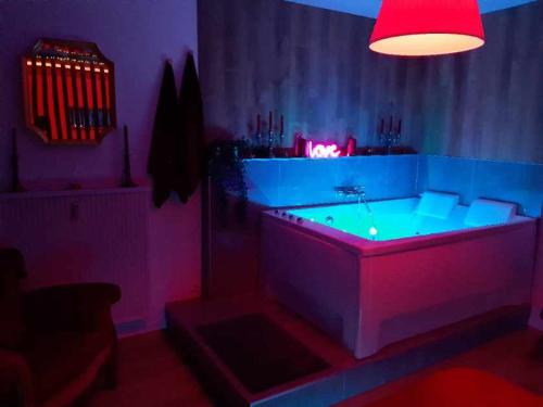 a dark room with a tub with a red light at Superbe appartement Colmar avec vue et Jacuzzi in Colmar