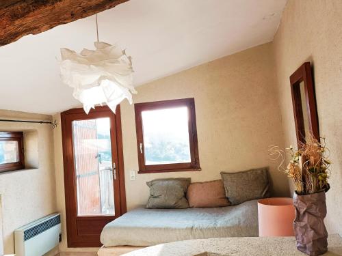 - un salon avec un lit et une fenêtre dans l'établissement Hôtel la Fête en Provence, à Vaison-la-Romaine