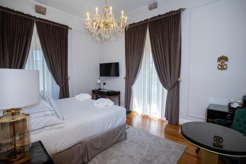 a bedroom with a white bed and a chandelier at Solar do Requeijo by Luna Hotels & Resorts in Arcos de Valdevez