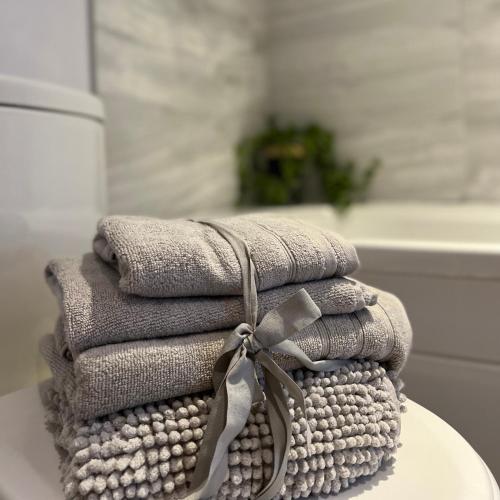 a stack of towels on a table in a bathroom at Honeysuckle Cottage & Whinfell Studio in Penrith