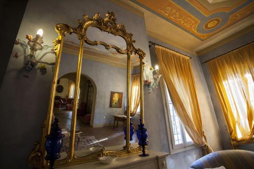 a room with a gold mirror on the wall at R&B Villa Tartaruga in Castelfranco Emilia