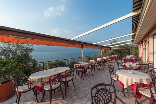 a row of tables and chairs on a balcony at Hotel Villa Carmen in Malcesine