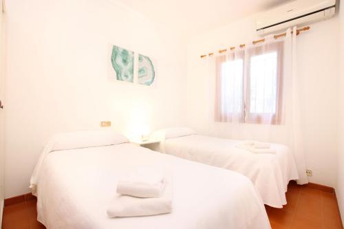2 camas en una habitación blanca con sábanas blancas en Villa Magraner Catalina, en Pollensa