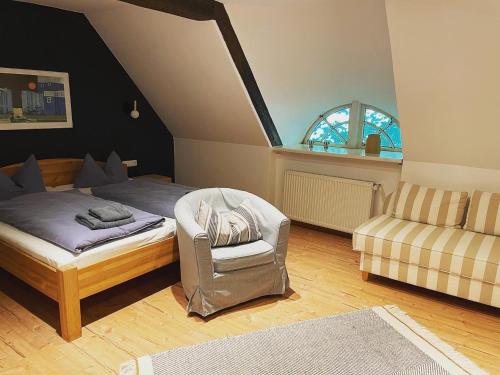 a bedroom with a bed and a chair and a window at Hotel Gut Schöneworth in Freiburg - Elbe