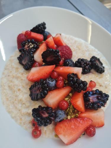 a plate of fruit on top of a plate of oatmeal at Natur Pur Hotel Unterpichl in Ultimo