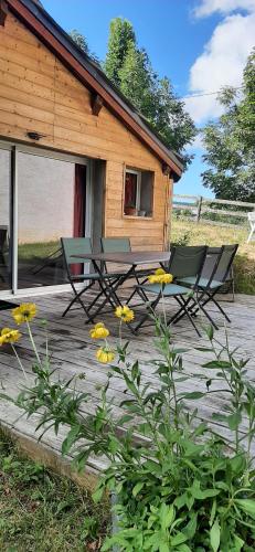 une terrasse avec 2 chaises et une maison dans l'établissement Gîte Toukoul, à Autrans