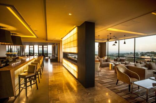 a restaurant with a bar and tables and chairs at Southern Sun Hyde Park Sandton in Johannesburg