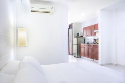 a white room with a bed and a kitchen at Santorini Villas Santa Marta in Santa Marta