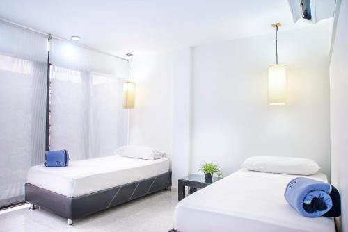 2 camas en una habitación con paredes blancas en Santorini Villas Santa Marta, en Santa Marta