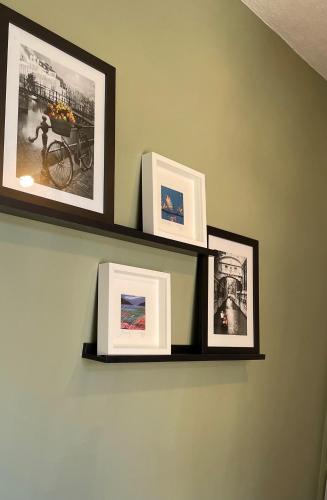 a shelf on a wall with pictures on it at Towerwell in Newburgh
