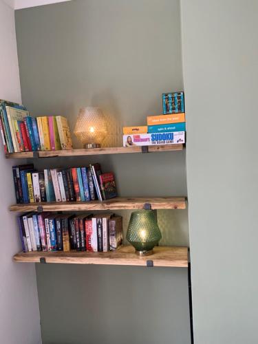 a book shelf filled with books and a lamp at Towerwell in Newburgh