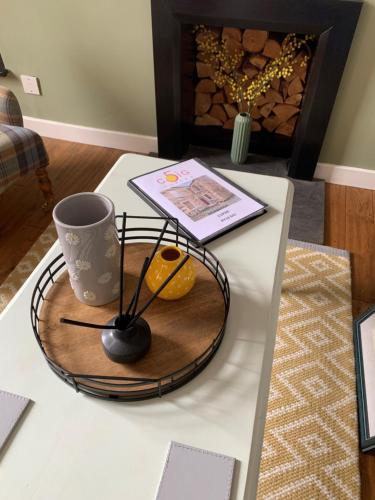 a table with a tray with a coffee cup and a book at Towerwell in Newburgh