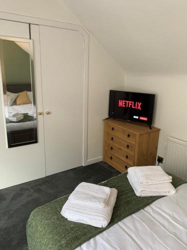 a bedroom with a bed and a tv on a dresser at Towerwell in Newburgh