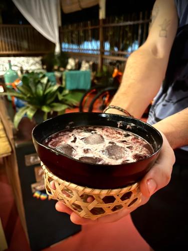 a person holding a bowl with a drink at Pousada Ocazum in Alter do Chao