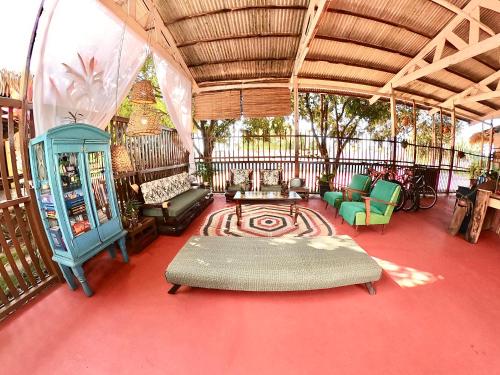a living room with a couch and chairs on a red floor at Pousada Ocazum in Alter do Chao