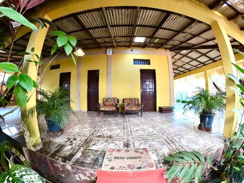 a lobby of a building with chairs and plants at Pousada Ocazum in Alter do Chao