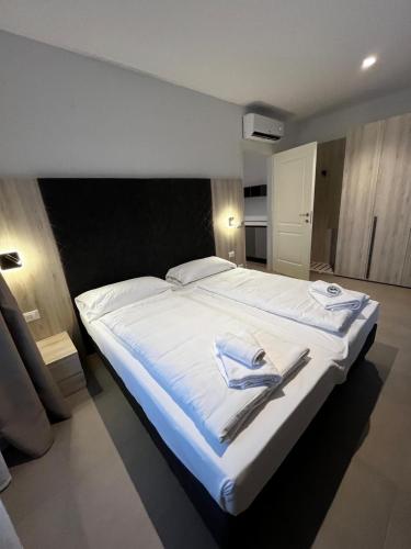 sypialnia z dużym białym łóżkiem z ręcznikami w obiekcie Bilo - Apartments for rent w Trydencie
