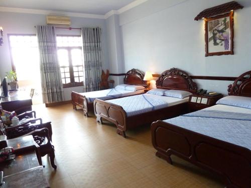 una habitación con tres camas en una habitación en Ca Ty Hotel, en Phan Thiet