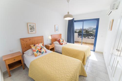 a hotel room with two beds and a balcony at Coloradas Villa Alba in Playa Blanca