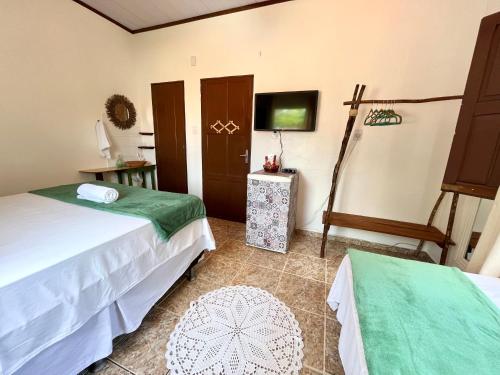 a hotel room with two beds and a tv at Pousada Ocazum in Alter do Chao