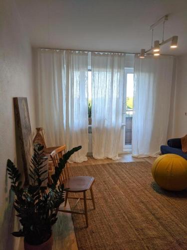 ein Wohnzimmer mit weißen Vorhängen und einem Sofa in der Unterkunft Õdus korter roheluses - A cozy apartment in a greenery - contactless check-in in Põlva