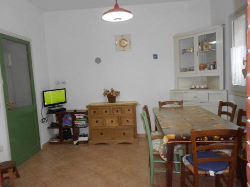 eine Küche und ein Esszimmer mit einem Tisch und einem TV in der Unterkunft La Lantana in San Vito