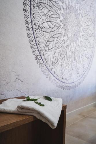 a towel on a table with a mandala wall mural at Olea Relais in Conversano