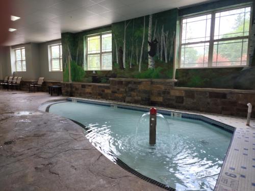 a swimming pool with a fountain in the middle of a building at La Quinta Inn & Suites by Wyndham Lake George in Lake George