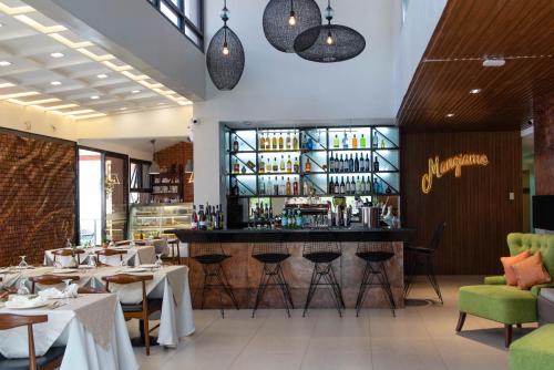 a restaurant with tables and chairs and a bar at Giraffe Boutique Hotel in Baguio
