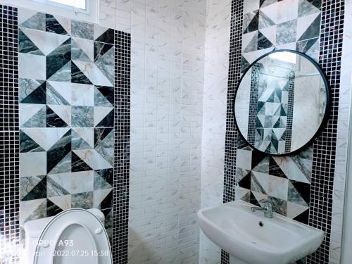 a bathroom with a toilet and a sink and a mirror at บ้านวาริ สะแกกรัง in Uthai Thani