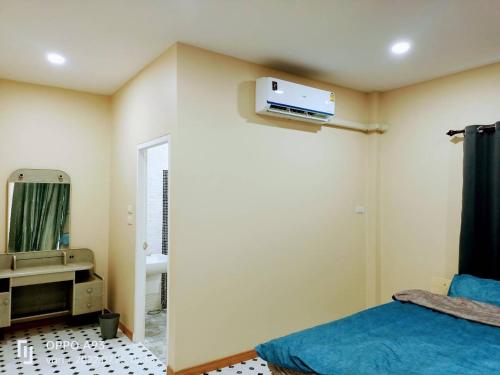 - une chambre avec un lit, un miroir et un lavabo dans l'établissement บ้านวาริ สะแกกรัง, à Uthai Thani