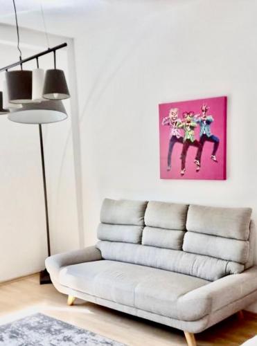 a living room with a couch and a pink painting at Apartment Living Leipzig in Großzössen
