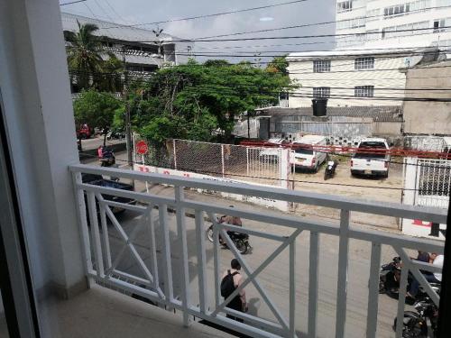 balcón con vistas a una calle con vehículos en Hostal Raatid Manchy en San Andrés