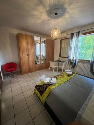 a bedroom with a large bed and a red chair at La Mimosa in Porto Garibaldi