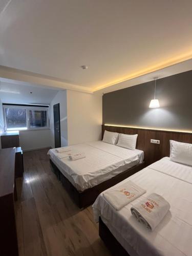 a hotel room with two beds and a desk at Kubi Hotel in Struga