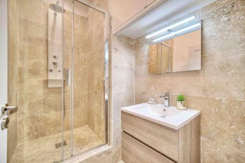 uma casa de banho com um lavatório e um chuveiro em CROISETTE 8/10 pers em Cannes