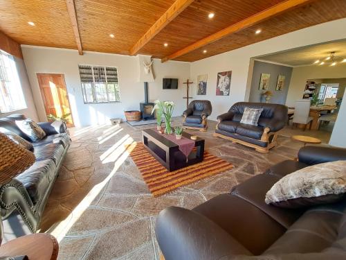 a living room with leather couches and a table at The Outpost Dullstroom in Dullstroom
