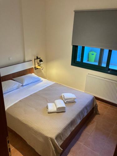 a bedroom with a bed with two towels on it at enJOY Golden beach in Skala Potamias