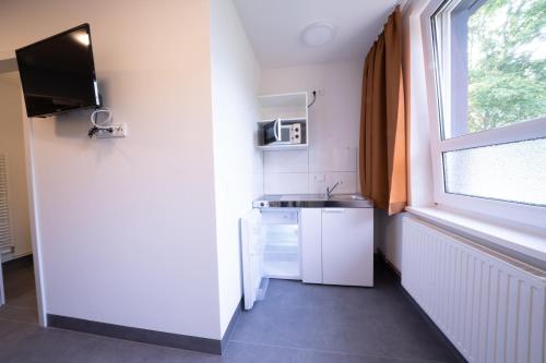 a small kitchen with a sink and a window at NeoHostel in Berlin