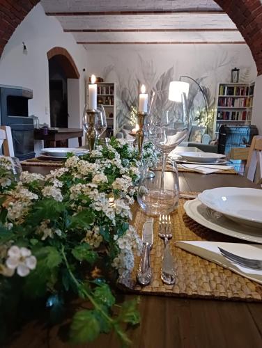 a dining room table with flowers and plates and silverware at Ca'Novae - Tuscany Farmhouse in Montieri