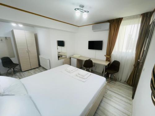 ブカレストにあるHotel Marina srlのベッド、デスク、テレビが備わる客室です。