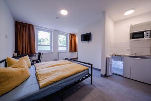 sypialnia z łóżkiem i kuchnią w obiekcie NeoHostel w Berlinie