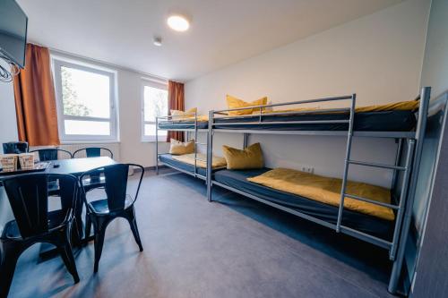 a room with bunk beds and a table and a dining room at NeoHostel in Berlin