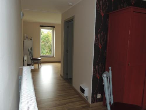 a room with a hallway with a red cabinet and a stairway at B&B Die Alte Scheune in Manderfeld