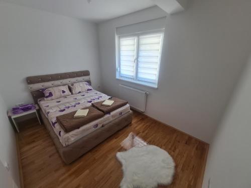 a bedroom with a bed and a white cat in it at Apartman CRYSTAL in Brčko
