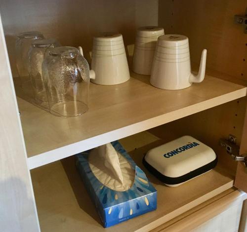 a shelf with various items in a cabinet at Silvia's Bed und Breakfast in Luzern in Luzern