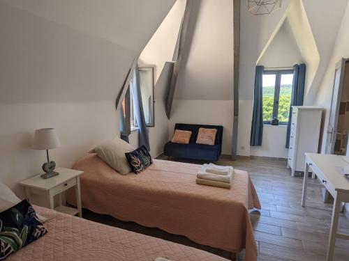 TursacにあるDomaine de Fleurieのベッド2台と椅子が置かれた部屋