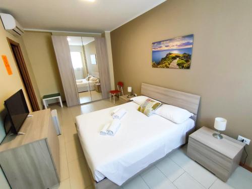 a bedroom with a large white bed and a desk at Grab a Flat in Coroneo in Trieste